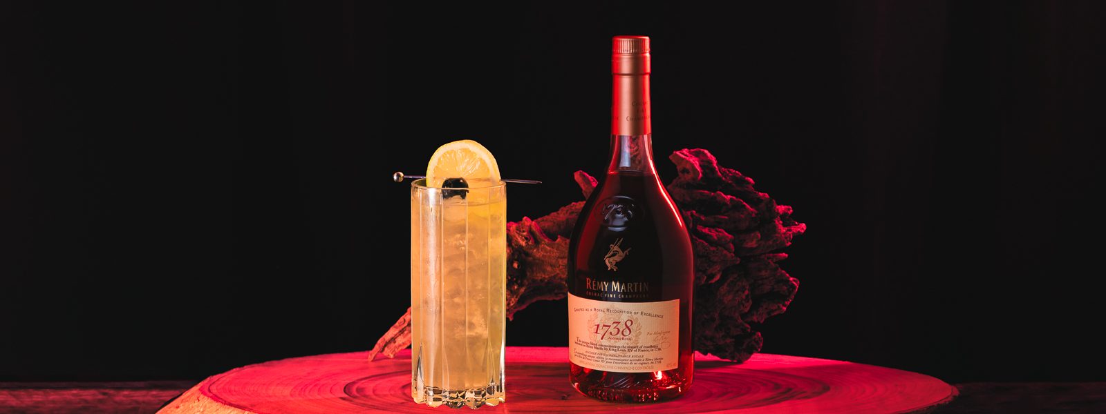 Rémy Martin 1738 Royal Collins in a highball glass with Remy Martin bottle